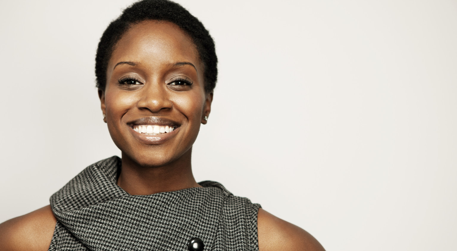 woman with short hair in business attire smiling brightly