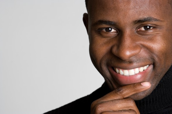 man with a hand on his face smiling