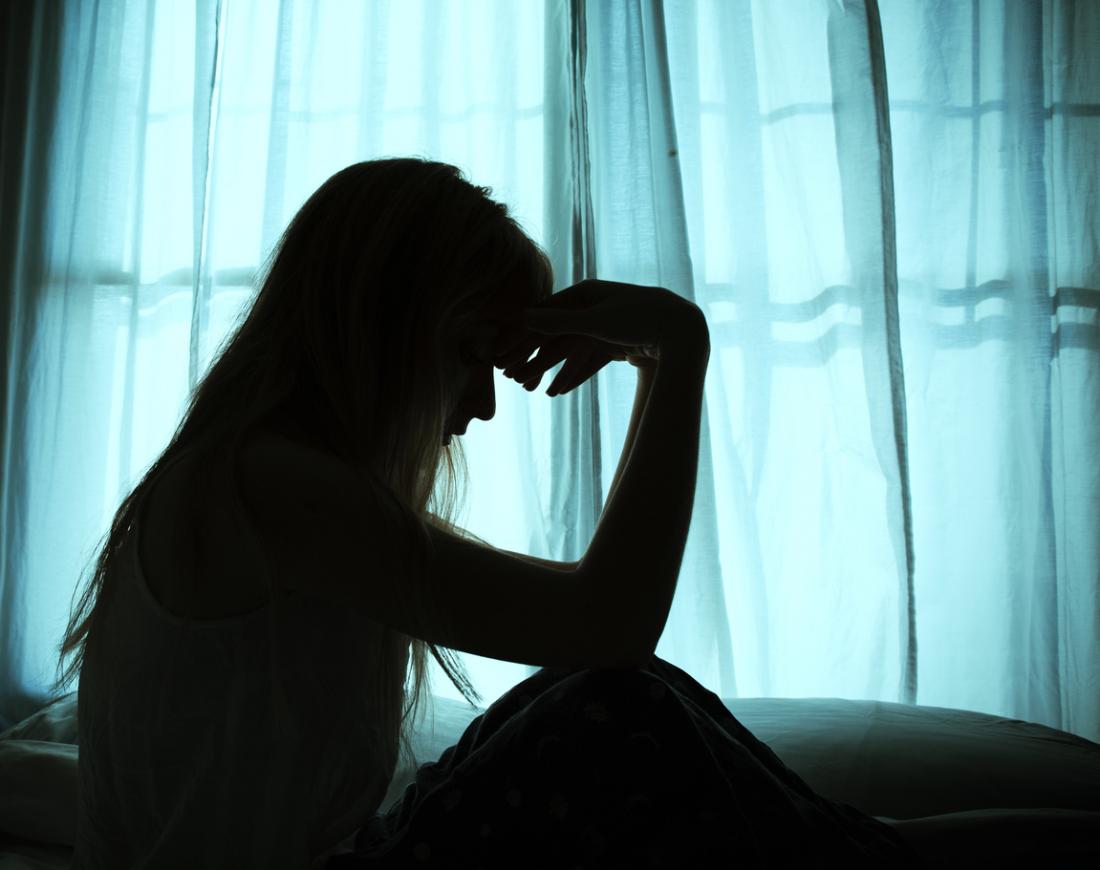 silhouette of a woman sitting alone in the dark