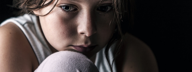 small child curled up in the dark